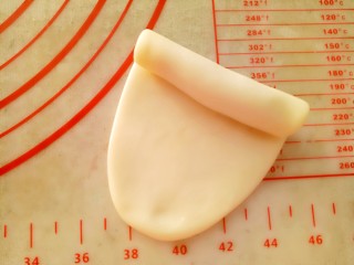 8、蛋黄酥,把包好的酥皮用擀面杖擀成牛舌形（长度10CM左右）卷起来。
