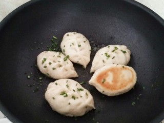 15、早餐生煎包,收干水分,撒上一些香葱碎即可出锅。