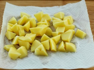3、香辣孜然土豆块,用清水冲洗掉表面淀粉，放到厨房纸上吸干水分