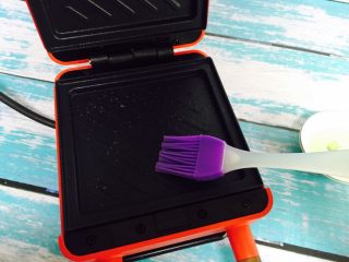 10、爆浆芒果酸奶吐司,在三明治盘中刷上花生油