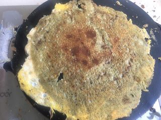 17、正宗天津煎饼果子,用两个铁铲一点点的先掀开边 使面饼与锅分离开，迅速翻面。