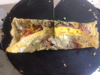 24、正宗天津煎饼果子,用铲子在中间 插一下，不要完全插断，把薄脆插断就好。