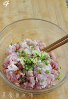 4、上海生煎,面团发酵的时候,拌肉馅。猪肉馅中加入盐、鸡精、老抽、料酒、葱花、姜末拌匀,再加入肉皮冻(没有肉皮冻就加清水),搅拌上劲,肉馅就做好了。