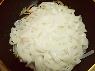 17、虾仁鸡蛋炒河粉,将冷水冲洗过的河粉抓入锅中。