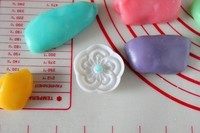 9、立体月饼,取一个花片，粘熟粉，磕出多余的粉，取一点蓝色冰皮搓成小球球放花片中间花心凹槽里。