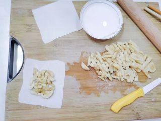 9、嫩脆香蕉派,冷藏好的饺子皮拿出来,铺一张在下面,把香蕉碎放上去,四周留边。