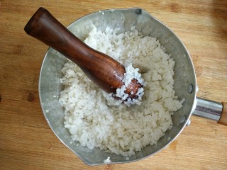 5、奶香蔓越莓米糕――剩米饭秒变高逼格小甜品,将拌入糖奶的米饭放入蒸锅（微波炉）加热5分钟，让白糖充分融化，增加米饭的粘性，并用木杵将米粒捣烂至粘稠（这时候米饭已经非常粘了）。