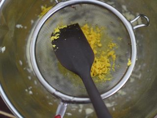 4、巧克力豆玛格丽特饼干,然后将煮熟的蛋黄过筛到黄油盆子里。用刮刀压按的方式过筛很容易过筛下去的。