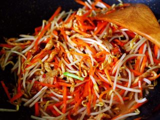 12、三丝春卷~饺子皮版,加入胡萝卜丝和绿豆芽,大火继续翻炒均匀。