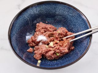 7、小白菜磷虾大馅馄饨,先把搅打好的肉馅放入大一点的容器，放入料酒和生抽，花椒粉和适量的盐，鸡精顺时针方向搅拌上劲。