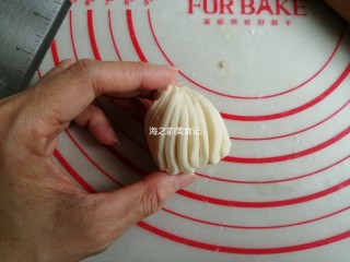 11、漩涡馒头卷,然后把筷子抽出来，右手捏出顶端，左手抓住下端顺时针旋转起来，顶端尖出来的部分捏掉