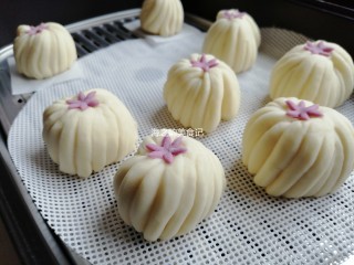 14、漩涡馒头卷,把小花放在顶端，为了使小花粘得更牢固，用手指沾一点点水在其中一面，再放上去。放在温暖处醒发20-30分钟，看见馒头胚明显大一些，才可以上锅蒸