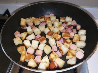 7、馒头抱蛋,放入香肠一起煎制。