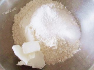 1、红曲酥，中式糕点,油皮材料中的面粉加白糖、猪油，用手搓匀。倒入温水，混合均匀