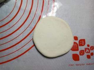 7、红豆包,取一个小剂子，揉圆摁扁，用擀面杖将皮擀开来。