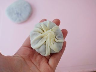 10、饺子皮紫薯饼,像包包子一样捏起来,收口有多余的饼皮可以捏掉一些,这样收口处的饼皮不会太厚