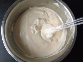 8、酸奶小蛋糕,再将蛋黄盆所有材料倒入蛋白霜,再用刮刀由下而上翻拌均匀;