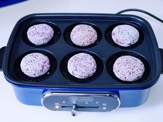 15、补血养颜～低脂紫薯红糖糯米饼,将做好的紫薯红糖糯米饼放入每个孔中！低温煎至两面微黄即可出锅！