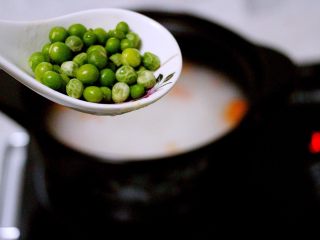 7、剩米饭也有春天(海鲜杂蔬粥),打开锅盖加入青豆