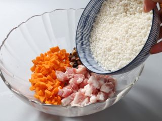 7、糯米蛋,将浸泡好的糯米沥去水，放入切好的五花肉、干香菇、胡萝卜丁中国。