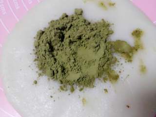 10、冰皮月饼#中秋食饼记#,做绿色抹茶冰皮，把其中一份冰皮按压成饼状，将抹茶粉过筛到上面，像叠被子的方法捏揉均匀