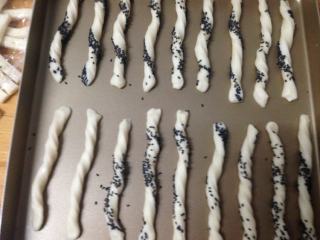 10、低脂小点――奶香面包棒,摆入烤盘，将面包棒上喷少许水，加盖保鲜膜。饧发30分钟