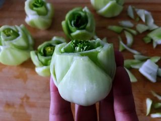 3、绿玫瑰花,用剪刀或者小刀把最外面一层剪出三角形。