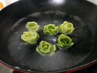 6、绿玫瑰花,放入绿色的玫瑰花焯水3分钟左右捞出，其间翻动花朵，保证从里到外都能熟。