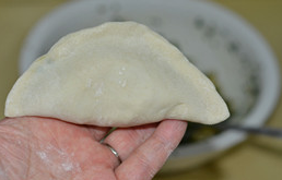 8、韭菜盒子,对折,捏紧二条边。