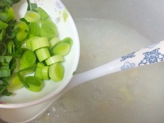 15、软糯玉米土豆咸粥,加入蒜苗搅拌一下后关火（如果粥的水比较多可多煮一会儿稍微煮浓稠一些再加蒜苗）