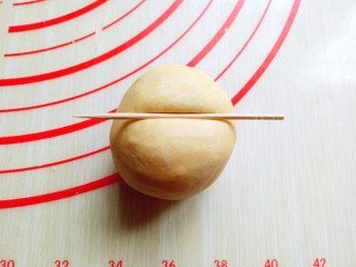 8、#甜味#香甜糯的南瓜饼#,揉圆的面团整理一下，利用牙签压出南瓜的纹路，首先牙签再面团顶端中间处压一下印痕，如图。