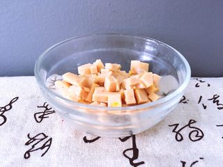 4、早餐+杂蔬粥 养生粥,将玉米肠切成小块用碗装好