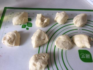 6、肉松小面包,面团拿到案板上排掉大气泡，分成九个大小均匀的面剂子。