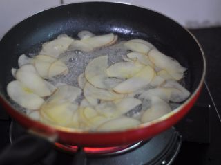 9、苹果花土司盒,苹果片切好后，我们开始把白糖倒进锅里，加入水，开火把白糖融化一下。糖水沸腾后把苹果片放进去，烫一下，苹果片软化立刻关火，煮久了苹果的颜色会变