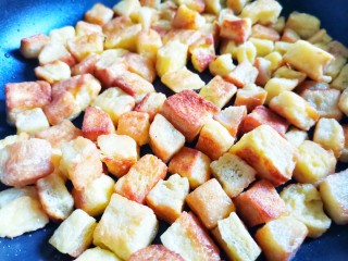 8、孜然火腿吐司丁,热锅倒油，放入吐司丁煎至金黄后盛出。