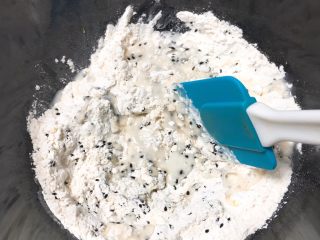 5、松软芝麻包,加入清水，用刮刀拌匀。