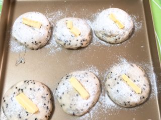 13、松软芝麻包,发酵完成后，表面刷上高筋粉，用锋利的刀切一刀，放入黄油。