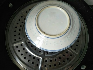 11、双皮奶(懒人版),碗上盖个盘子防止水汽倒流到水中,再盖好锅盖大火蒸二十分钟。