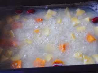 10、双色红薯糯米粥,大火继续炖煮至双色红薯块变软。