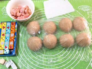 15、奶油黑麦奶酪包,面团分成八个剂子，盖上保鲜膜静置20分钟，火腿肠切小片，干奶酪和沙拉酱准备好。