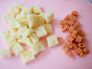 2、芝士焗吐司,吐司切去四边，再切成小块，火腿肠切小块备用