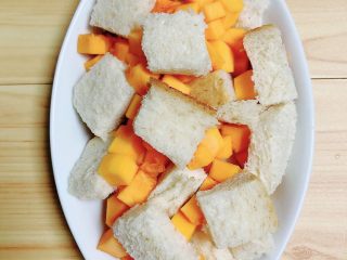 8、南瓜烤吐司布丁,将切片面包块和南瓜块放入烤盘中。