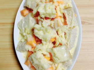 12、南瓜烤吐司布丁,再淋上一层炼乳。将烤盘放入到烤箱中，180度烤15-20分钟，即可出炉。