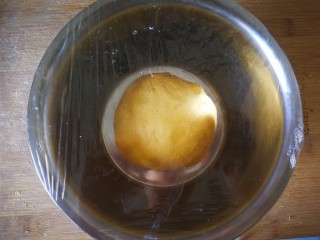 8、千层手撕南瓜馒头,揉成光滑的面团盖上保鲜膜放盆里等待发酵。