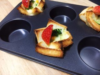 16、吐司披萨盏,在吐司披萨盏上插上草莓即可。