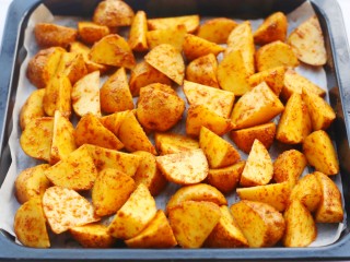 8、好吃到吮指的烤薯角,处理好的土豆放入铺好油纸的烤盘中。