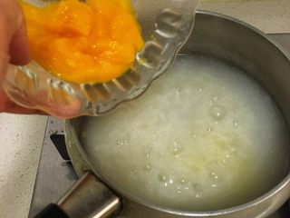 10、宝宝辅食8M➕：南瓜蛋黄十倍粥,此时大米粥已经基本上煮好，将南瓜泥倒入粥中一起煮