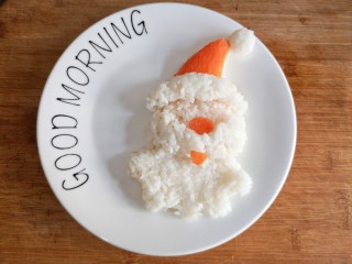 11、圣诞咖喱鸡饭,将胡萝卜切薄片，剪成帽子，鼻子，嘴的形状，摆在适当的位置。