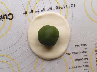 5、抹茶酥,十分钟过后取一个油酥将其按扁将油酥放入中间