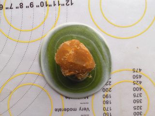 17、抹茶酥,拍扁后 将酥皮翻个面，用擀面杖 稍微擀开一点，然后将莲蓉肉松馅放在中间